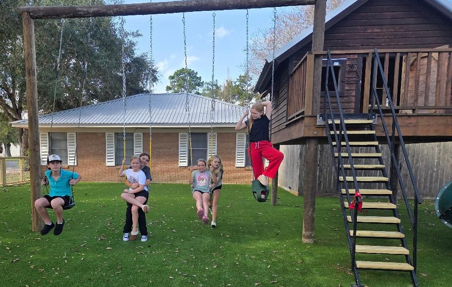 Children laughing and playing on swings at St. John Lutheran Church Cat Spring.